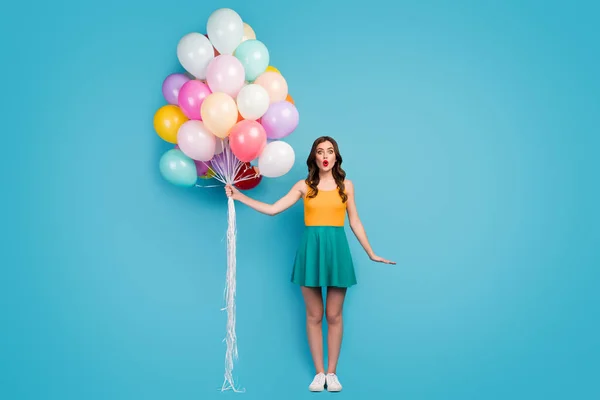 Foto de comprimento total de menina surpreendida comemorar seu aniversário com amigos recieve sonho presente segurar muitos ar balão olhar estupor desgaste gumshoes tank-top isolado azul cor de fundo — Fotografia de Stock