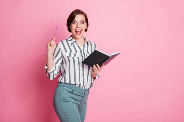 Omg невероятная идея. Впечатленная девочка студентка написать эссе держать книгу поднять карандаш крик Вау невероятно носить серые белые брюки брюки изолированы на розовом фоне — стоковое фото