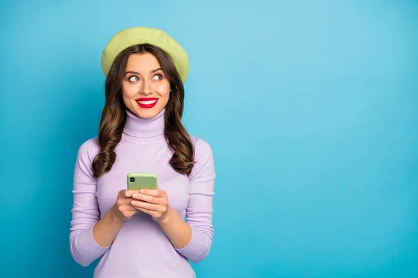 Retrato de positivo alegre vermelho lisp mulher chill uso smartphone repostar mídia social notícias olhar copyspace acho que desgaste estilo elegante moda jumper headwear isolado sobre azul cor fundo — Fotografia de Stock