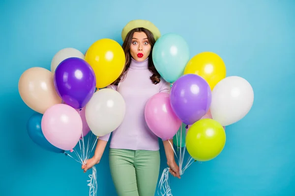 Фото смішної леді несе багато барвистих повітряних кульок несподівано вечірка з несподіваним відкритим ротом носить фіолетовий джемпер з беретовою шапочкою зелені штани ізольовані синій колір фону — стокове фото