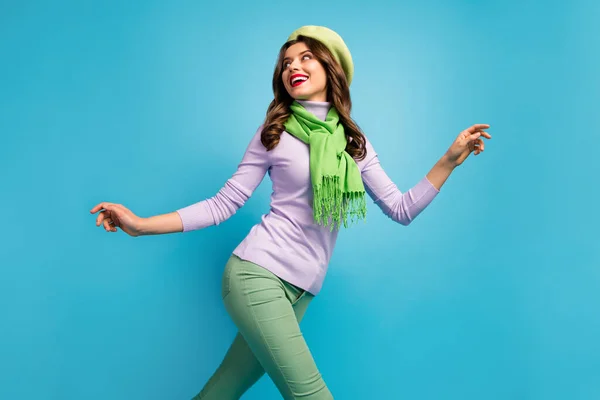 Χαμηλή παρακάτω γωνία προβολή προφίλ φωτογραφία του γοητευτικό όμορφη κυρία ταξιδιώτη με τα πόδια δρόμο ενθουσιασμένοι διάθεση φορούν πράσινο μπερέ καπέλο μοβ πουλόβερ μαντήλι παντελόνι απομονωμένο μπλε χρώμα φόντο — Φωτογραφία Αρχείου