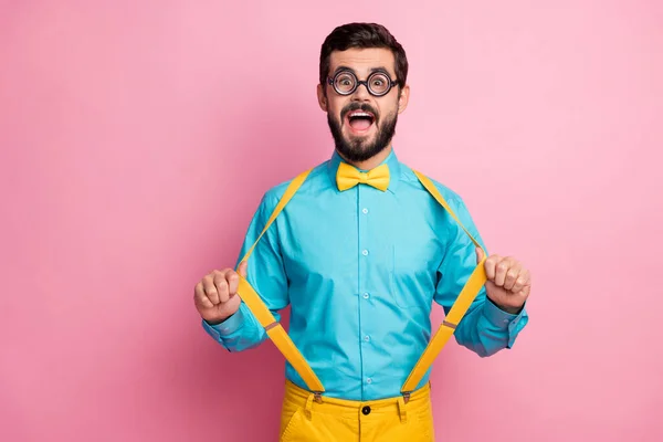 Retrato de su agradable atractivo cómico funky infantil alegre alegre barbudo nerd chico usando finas especificaciones menta camisa tirando tirantes divertirse aislado sobre pastel rosa color fondo — Foto de Stock