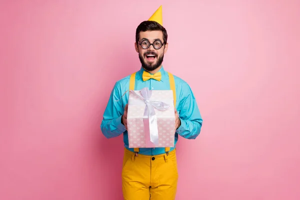 Πορτρέτο του ο ωραίος ελκυστικός funky κωμικός χαρούμενα γενειοφόρος τύπος φορώντας festal βλέμμα κρατώντας στα χέρια δίνοντας χειρισμό giftbox απομονώνονται σε παστέλ ροζ χρώμα φόντο — Φωτογραφία Αρχείου