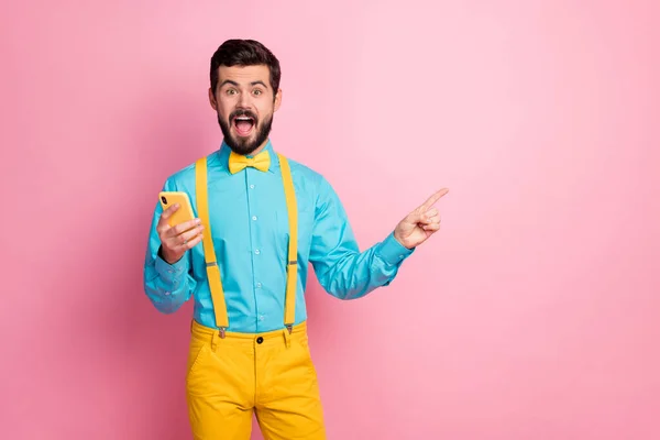 Portrait of his he nice attractive cheerful cheery amazed excited bearded guy holding in hands cell showing copy space advice solution new novelty isolated over pastel pink color background — 스톡 사진
