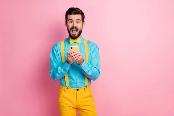 Retrato dele ele agradável alegre atraente alegre alegre louco barbudo cara segurando em mãos celular grande notícia smm velocidade rápida conexão isolada sobre pastel cor-de-rosa fundo — Fotografia de Stock