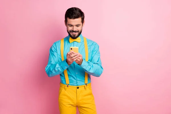 Portrait of his he nice attractive cheerful cheery focused bearded guy wearing mint blue shirt holding in hands cell chatting online isolated over pastel pink color background — Stock Photo, Image