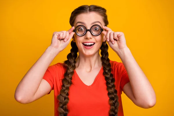 Fotografie legrační hezká studentka chytrá pilný žák držet brýle ruce otevřené ústa korekce zraku nosit blázen specifikace ležérní červená t-shirt izolované světle žlutá barva pozadí — Stock fotografie