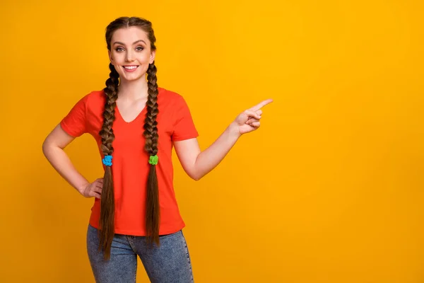 Foto di abbastanza eccitato signora dito diretto lato spazio vuoto dimostrando novità prodotto prezzi bassi indossare casual rosso t-shirt jeans isolato luminoso colore giallo sfondo — Foto Stock