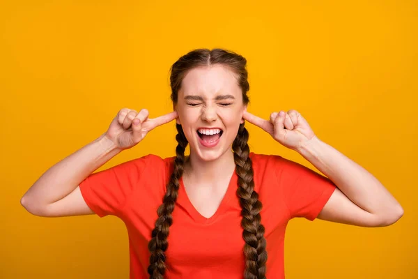 Foto de loca dama disgustada sostener los dedos dentro de las orejas gritando en voz alta los ojos cerrados sufriendo tensión migraña dolor desgaste casual rojo camiseta aislado vívido color amarillo fondo — Foto de Stock