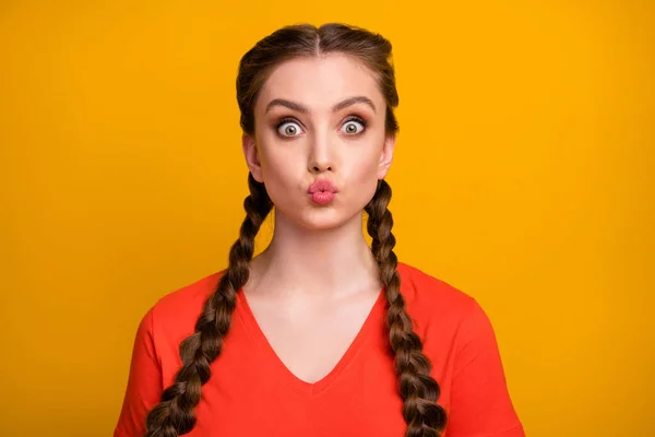 Primeros planos foto de divertida dama alegre atractiva dos lindas trenzas largas enviando besos de aire chico guapo humor juguetón desgaste casual camiseta roja aislado vibrante color amarillo fondo — Foto de Stock