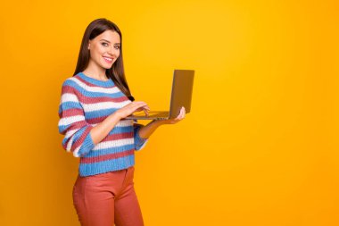 Portrait of her she nice attractive lovely cheerful cheery confident brown-haired girl holding in hands using laptop wi-fi isolated over bright vivid shine vibrant yellow color background clipart