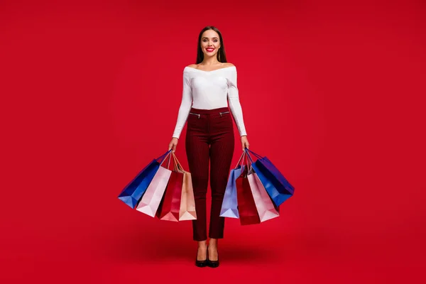正の見事な上品な女性のショッピングセンターの訪問者の完全な長さの写真多くのバッグを保持チェックパンツ白い靴まだ上に隔離された明るい輝きの色の背景 — ストック写真
