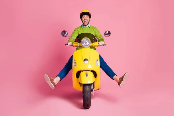 Portret van zijn hij mooi aantrekkelijk gek kinderachtig zorgeloos vrolijk blij jongen paardrijden bromfiets plezier fooling geïsoleerd over roze pastel kleur achtergrond — Stockfoto