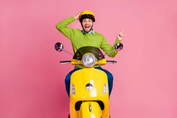 Retrato de su agradable atractivo sorprendido alegre alegre alegre chico montando moto mostrando anuncio aviso consejo nueva decisión aislado sobre rosa pastel color fondo —  Fotos de Stock