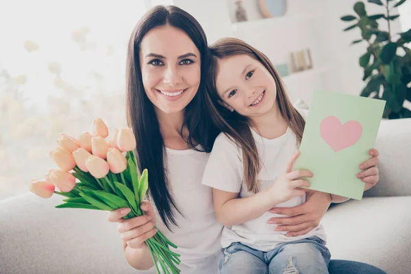 Happy 8-march family celebration. Positive cheerful mommy and her daughter sit couch hold bloom blossom roses bouquet postcard enjoy free time festive event in house indoors
