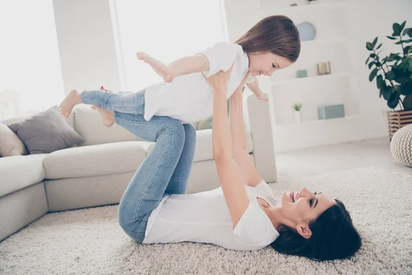 Full length photo of cheerful cute adorable mommy lay carpet hold her small kid imagine she fly like bird in living room apartment house indoors — Stock Photo, Image