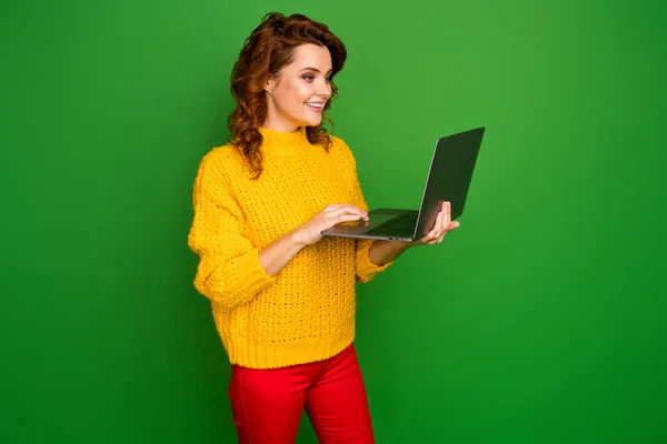 Profile photo of pretty cheerful lady hold notebook hands browsing freelance IT website administrator wear yellow knitted sweater red pants isolated green color background