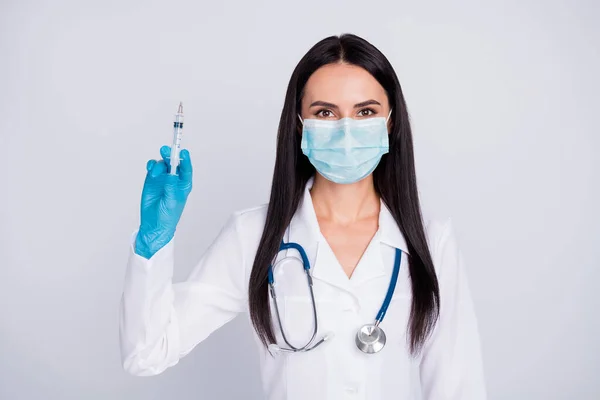 Foto de hermosa dama doc listo para la operación joven cirujano profesional mantenga la anestesia jeringa usar guantes máscara estetoscopio blanco bata de laboratorio aislado color gris fondo — Foto de Stock