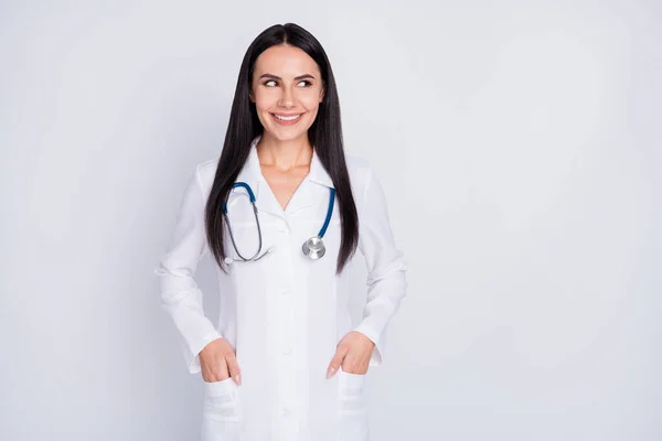 Foto de atractivo amigable médico señora consulta centro de rehabilitación aspecto profesional espacio vacío desgaste blanco larga bata de laboratorio estetoscopio aislado color gris fondo —  Fotos de Stock