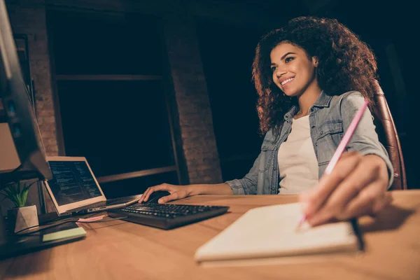 Positief geschoolde afro-Amerikaanse professionele hacker meisje zit tafel bureau gebruik computer werk start-up bedrijf besturingssysteem software verbetering schrijf tips copybook in werkplek werkstation — Stockfoto