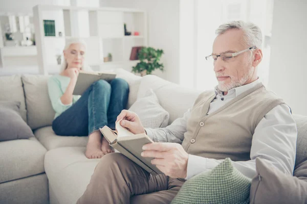 Retrato de encantadora pareja casada con pantalones vaqueros pantalones jersey gafas gafas lectura libro de papel sentarse diván en casa —  Fotos de Stock