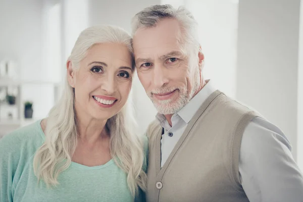 Foto de cerca de los abuelos encantadores que buscan usar pullovers de color marrón azulado camisa de pie en la habitación —  Fotos de Stock