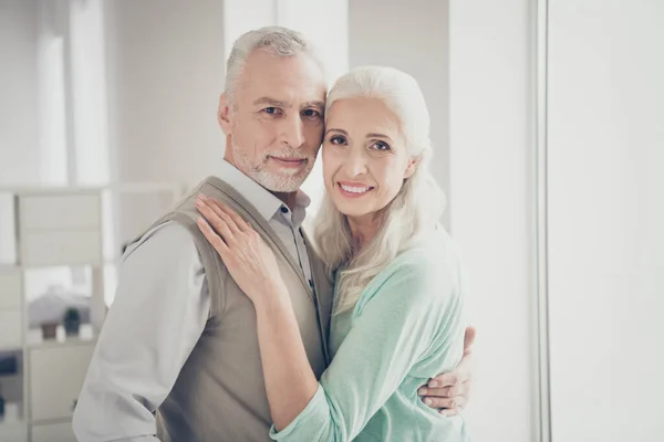 De cerca la foto de los enamorados encantadores jubilado encontró amor verdadero abrazo teal vestido pullovers marrones de pie en la habitación —  Fotos de Stock