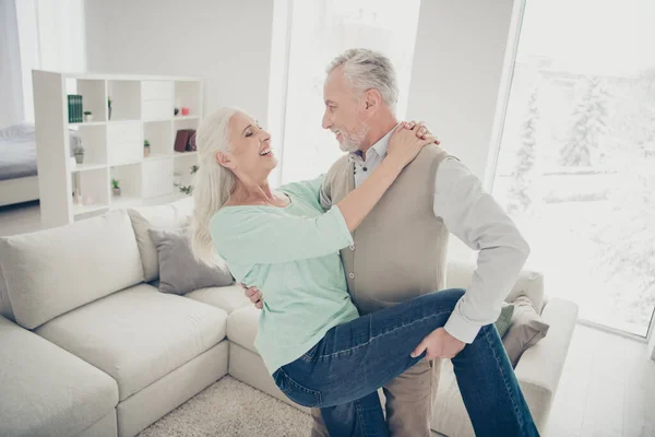 Retrato de alegres encantadores cônjuges se movendo rindo no apartamento vestido calças jeans jeans camisola marrom teal — Fotografia de Stock