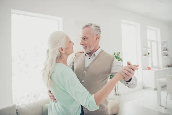Retrato de personas casadas encantadoras cogidas de la mano moviéndose en casa apartamento vestido de color verde azulado jerséis marrones — Foto de Stock