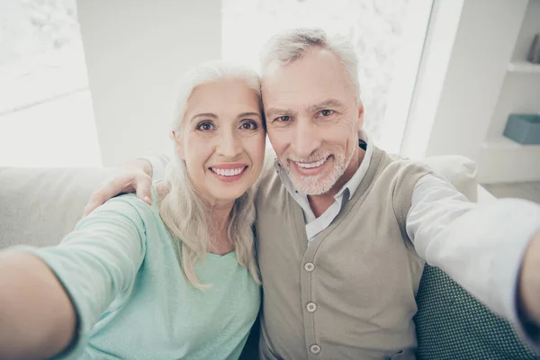 De cerca la foto de los padres encantadores en suéteres haciendo fotos sentarse sofá en la habitación grande apartamento plano —  Fotos de Stock