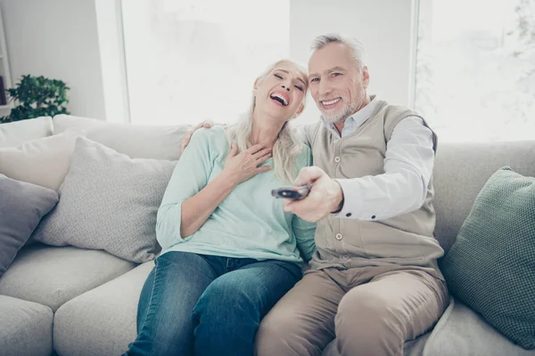 Familia de pareja de personas mayores pasar tiempo libre juntos cambiando de canales encontrado humorístico show sentarse sofá — Foto de Stock