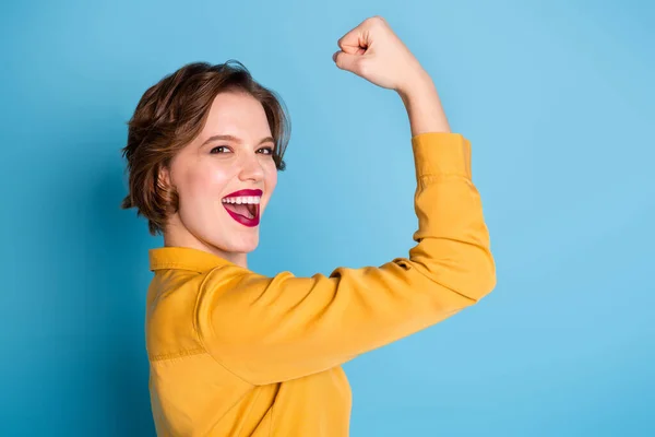 Profile photo of pretty cheerful lady hold raise biceps hand arm show perfect biceps gym training strong powerful woman wear yellow shirt isolated bright blue color background — Stock Photo, Image