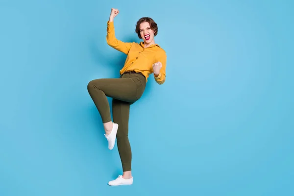 Foto de comprimento total de senhora de negócios bonita levantar punhos comemorando startup sucesso investimento renda desgaste amarelo camisa verde calçado isolado brilhante azul cor fundo — Fotografia de Stock