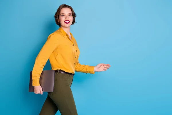 Perfil foto de senhora de negócios bonita segurar as mãos notebook trabalhador responsável andar reunião corporativa conferência desgaste amarelo camisa verde calças isoladas azul brilhante cor de fundo — Fotografia de Stock