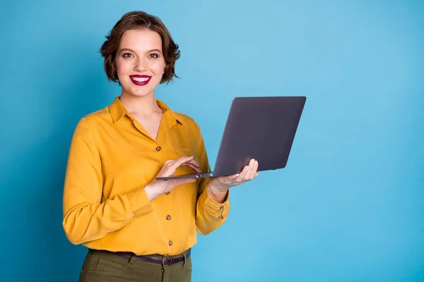 Foto de muito charmoso negócio senhora segurar notebook mãos busca informações servidor confiável responsável trabalhador desgaste amarelo camisa verde calças isolado brilhante azul cor fundo — Fotografia de Stock