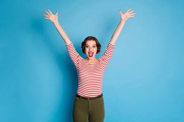 Foto de hermosa señora extática animadora loca levantar las manos apoyando equipo deportivo usar casual rojo blanco camisa verde pantalones aislados de color azul brillante fondo —  Fotos de Stock