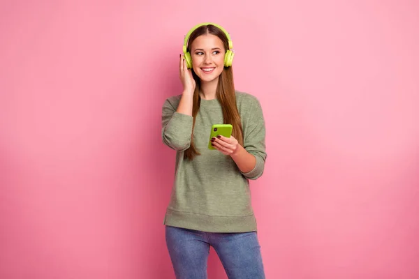 Portret van vrolijke opgewonden meisje gebruik smartphone luisteren muziek van online stereo radio kijken copyspace slijtage trui denim geïsoleerd over pastel kleur achtergrond — Stockfoto