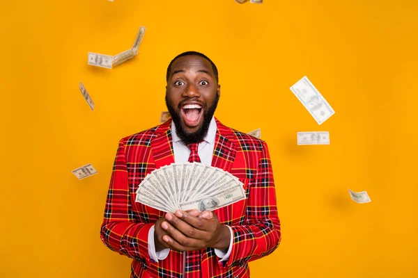 Photo of excited dark skin guy hold hands fan of usa bucks rich person millionaire money falling wear plaid red costume blazer shirt tie isolated yellow color background — Stock Photo, Image