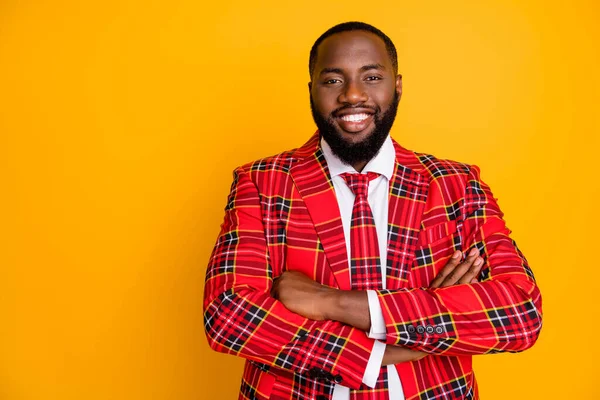 Foto van aantrekkelijke donkere huid man armen gekruist tand stralen glimlachende zelfverzekerde persoon dragen geruite rode kostuum blazer shirt das geïsoleerde heldere gele kleur achtergrond — Stockfoto