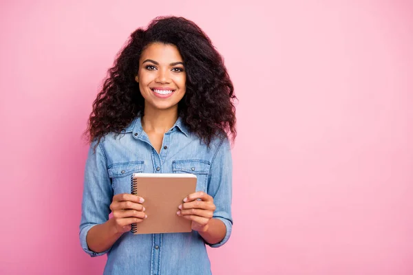 Portrait von positiven fröhlichen afroamerikanischen Mädchen halten Copybook College Student bereit erhalten Wissen tragen Casual Style Jeans Outfit isoliert über rosa Hintergrund — Stockfoto