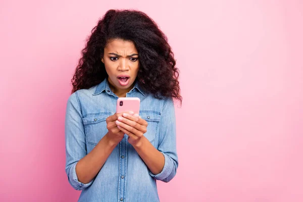 Omg comentarios horribles. Shocked chica loca utilizar su teléfono celular leer noticias de la red social impresionado grito wow llevar ropa elegante aislado sobre fondo de color rosa — Foto de Stock