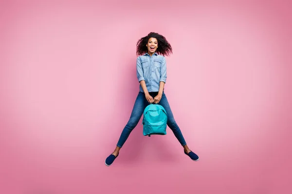 Foto de cuerpo completo de la chica afro-americana emocionada descanso relajarse después de la universidad estudio bolsa de sujeción desgaste casual estilo zapatillas aisladas sobre fondo de color rosa —  Fotos de Stock