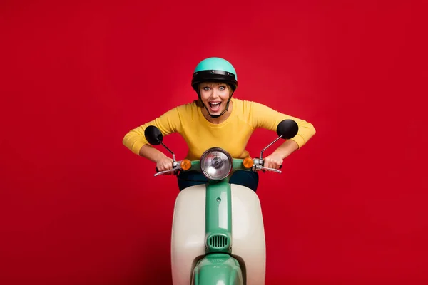 Portret van verbaasd vrolijke funky gek meisje verslaafd brommer scooter rijder rijden fiets genieten snelheid schreeuwen wow omg slijtage jumper geïsoleerd over levendige kleur achtergrond — Stockfoto