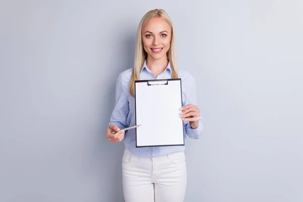 Ritratto di positivo allegro ragazza azienda proprietario tenere appunti con carta vuole segno partenariato punto penna spazio vuoto indossare pantaloni buon look isolato su sfondo di colore grigio — Foto Stock