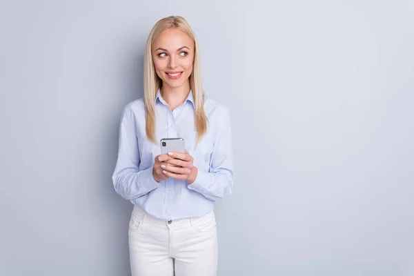Portrét krásné okouzlující dívka smm pracovník použít smartphone vzhled copyspace těšit sociální média komunikace novinky oblečení kalhoty izolované přes šedou barvu pozadí — Stock fotografie