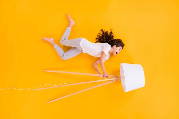 Corpo inteiro ângulo alto acima plano lay vista foto de bela louca engraçada senhora deitado segurar lâmpada de assoalho elétrica tendo divertido desgaste pijama isolado cor amarela fundo — Fotografia de Stock