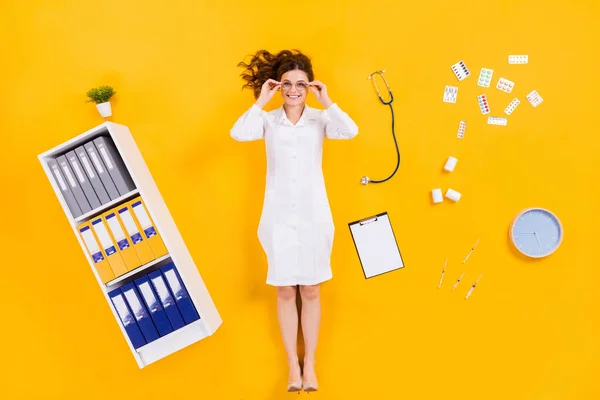 Parte superior por encima de ángulo alto ver foto de longitud completa de la mujer cualificada doc píldoras planas drogas portapapeles jeringa reloj toque especificaciones en consultorio médico aislado sobre brillante brillo color fondo — Foto de Stock