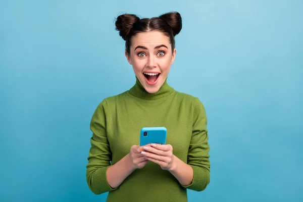 照片上漂亮的少女张嘴浏览电话阅读博客评论查看追随者穿着绿色套头毛衣孤立的蓝色背景 — 图库照片