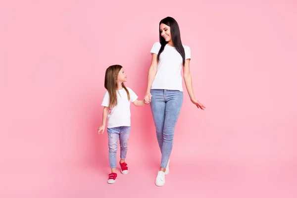 Comprimento total tamanho do corpo vista de dois agradável atraente bonita alegre bonita alegre cuidadoso melhor irmãs andando gostando de segurar as mãos isoladas sobre fundo cor pastel rosa — Fotografia de Stock