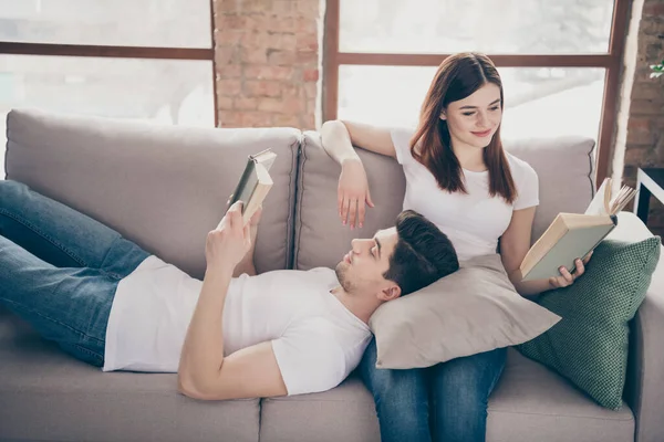 Retrato de sua ele ela agradável atraente lindo focado alegre casal sentado deitado em divã leitura interessante livro passar tempo passatempo no moderno estilo loft industrial tijolo interior — Fotografia de Stock